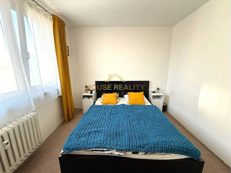 Pekný zariadený 3 izbový byt s lodžiou, Púpavová ulica, BA.Karlova Ves - Spálňa s posteľou, žltými vankúšmi a modrou prikrývkou v 3-izbovom byte.