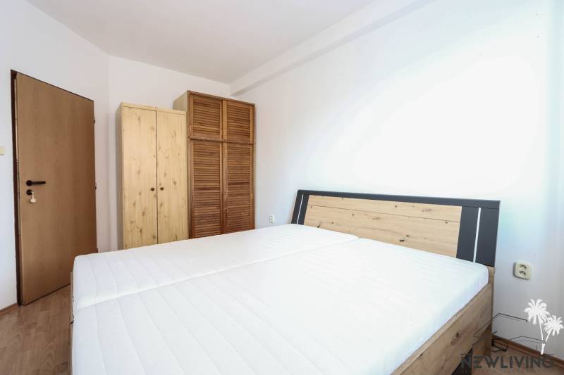 Na prenájom 2 izbový byt v Piešťanoch - Spálňa v 2-izbovom byte s posteľou a drevenými skriňami, podlaha s dreveným dekorom.