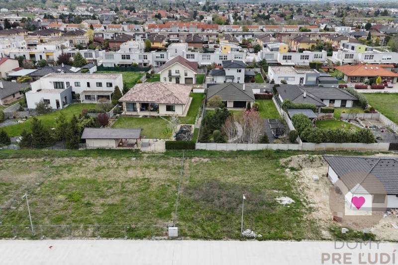 Praktický a úsporný rodinný dom v Bernolákove, Jelšova - Rodinné domy v Bernolákove na Jelšovej ulici, obklopené záhradami a zelenými plochami.