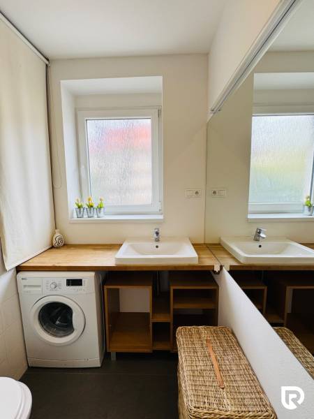 Tichý 2i byt v TOP Lokalite Nív | Trenčianska, BA - Kúpeľňa s umývadlom, zrkadlom a práčkou v 2-izbovom byte.