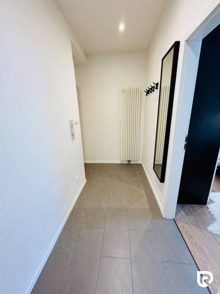 Tichý 2i byt v TOP Lokalite Nív | Trenčianska, BA - Chodba v 2-izbovom byte s dlažbou, vešiakmi a kachľovým radiátorom.