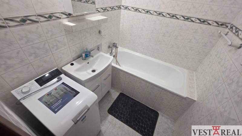 Prenájom veľký 1 izbový byt 48m2 Vráble- Centrum - Kúpeľňa s vaňou a práčkou v 1-izbovom byte, svetlé obklady a úložný priestor.