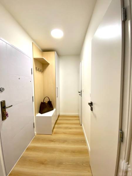 Dizajnový moderný 2 izbový byt Jurigovo nám. Bratislava IV Karlova Ves - Predsieň s podlahou s dreveným dekorom, skrinkou a vešiakom v 2-izbovom byte.