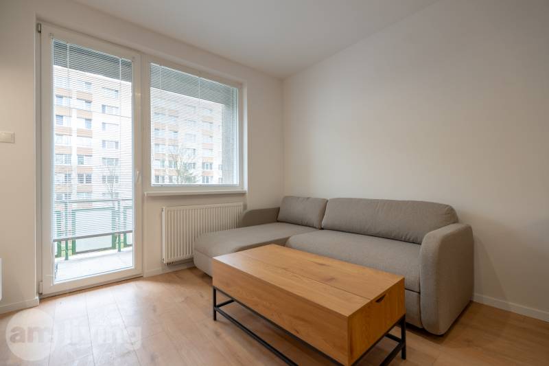 KOMPLETNÁ REKONŠTRUKCIA- 3i 54 m² + balkón - Dubnica nad Váhom - Šedá pohovka v 3-izbovom byte so stolíkom a podlahou s dreveným dekorom.