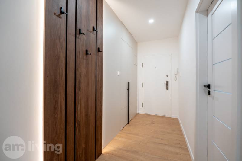 KOMPLETNÁ REKONŠTRUKCIA- 3i 54 m² + balkón - Dubnica nad Váhom - Úzka chodba so vstavanými skrinkami a podlahou s dreveným dekorom v 3-izbovom byte.