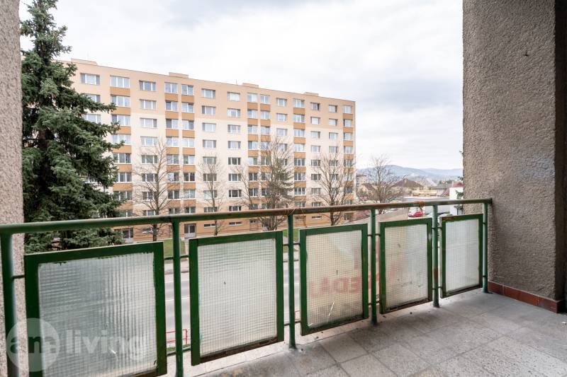KOMPLETNÁ REKONŠTRUKCIA- 3i 54 m² + balkón - Dubnica nad Váhom - Balkón 3-izbového bytu v Dubnici nad Váhom s výhľadom na bytový dom a zeleň.