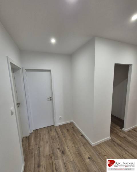 Prenájom 2-izbového bytu Bratislava II, Ružinov - Bielo natretá chodba v 2-izbovom byte s podlahou s dreveným dekorom.