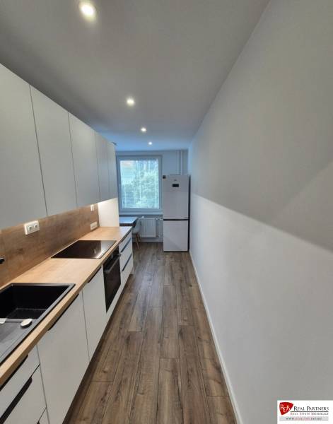 Prenájom 2-izbového bytu Bratislava II, Ružinov - Kuchyňa v 2-izbovom byte s dreveným obkladom a modernými spotrebičmi.