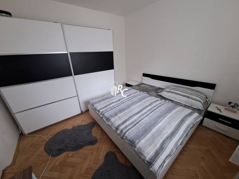 Predaj čiastočne prerobený 3 izbový byt Martin Sever - Spálňa v 3-izbovom byte s veľkou skriňou, manželskou posteľou a podlahou s dreveným dekorom.