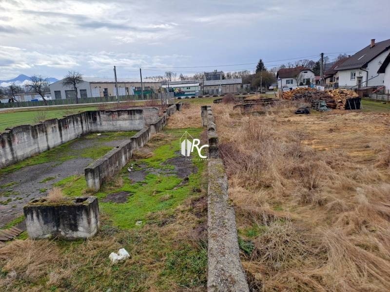 Stavebný pozemok 2 375 m² v obci Valča  - Pozemky - bývanie vo Valči s opustenými betónovými základmi a prírodnou vegetáciou.