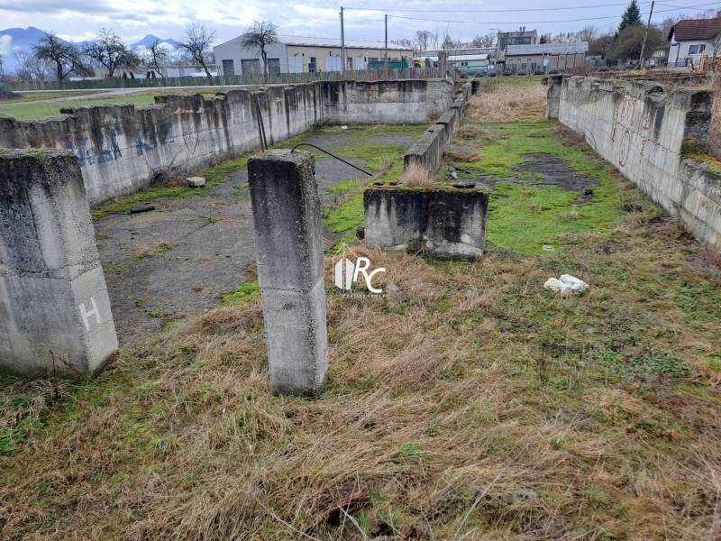 Stavebný pozemok 2 375 m² v obci Valča  - Staré betónové základy v Valči vhodné na Pozemky - bývanie, obklopené trávou a stromami.