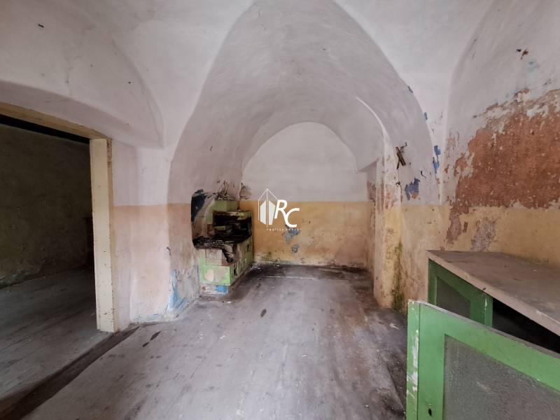 Rodinný dom v obci Háj v pôvodnom stave s veľkým potenciálom - Starý interiér rodinného domu s klenutým stropom a opotrebovanými stenami.