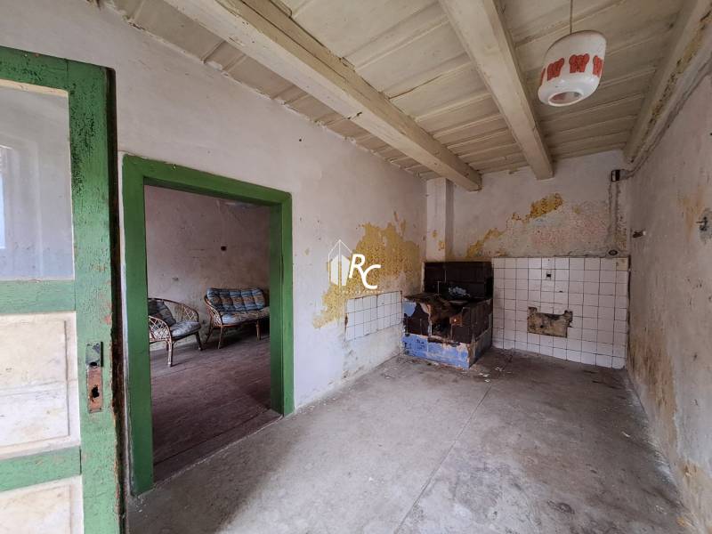 Rodinný dom v obci Háj v pôvodnom stave s veľkým potenciálom - Opustený interiér vidieckeho rodinného domu s hlinenou pecou a starým nábytkom.