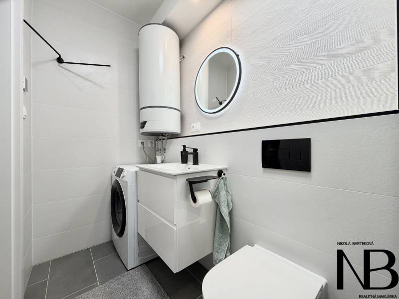 Na prenájom nový, komplet zariadený 1i byt - parking a loggia, Trenčín - Kúpeľňa v 1-izbovom byte s práčkou, bojlerom a zrkadlom v kruhovom ráme.