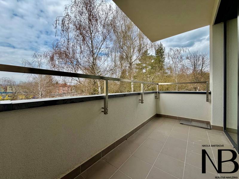 Na prenájom nový, komplet zariadený 1i byt - parking a loggia, Trenčín - Balkón 1-izbového bytu na Soblahovskej ulici v Trenčíne s výhľadom na stromy.