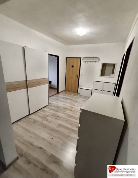 Predaj 4-izbového bytu na začiatku Petržalky Bratislava V - Chodba s bielym nábytkom a podlahou s dreveným dekorom v 4-izbovom byte.