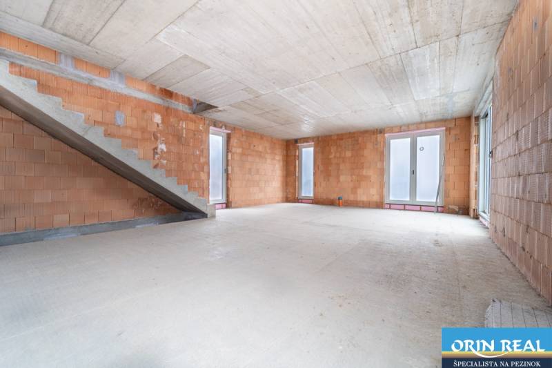 ATRAKTÍVNA MODERNÁ 5 IZB.ROZOSTAVANÁ VILA na KOLIBE - Priestranný interiér rodinného domu v nedokončenom stave s viditeľným schodiskom.