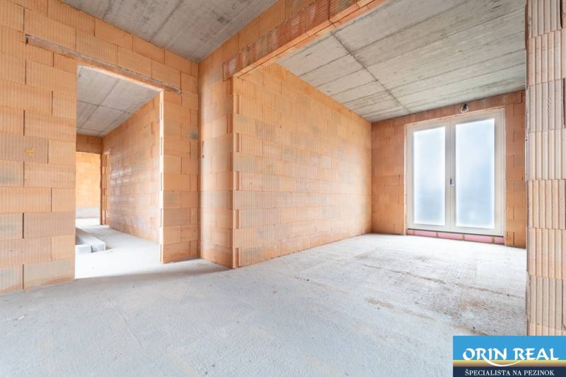 ATRAKTÍVNA MODERNÁ 5 IZB.ROZOSTAVANÁ VILA na KOLIBE - Stavba v interiéri rodinného domu s neomietnutými tehlovými stenami a betónovým stropom.