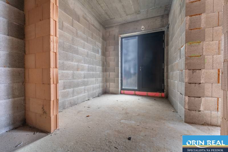 ATRAKTÍVNA MODERNÁ 5 IZB.ROZOSTAVANÁ VILA na KOLIBE - Stavebný priestor v rodinnom dome s pohľadom na betónovú podlahu a veľké dvere.