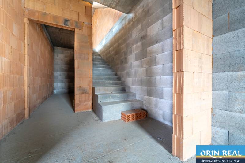 ATRAKTÍVNA MODERNÁ 5 IZB.ROZOSTAVANÁ VILA na KOLIBE - Nedokončené schodisko a surové tehlové steny v rodinnom dome.