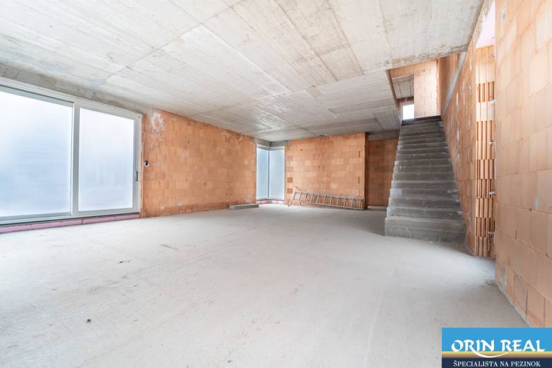 ATRAKTÍVNA MODERNÁ 5 IZB.ROZOSTAVANÁ VILA na KOLIBE - Holé steny a betónová podlaha v rodinnom dome so schodiskom.