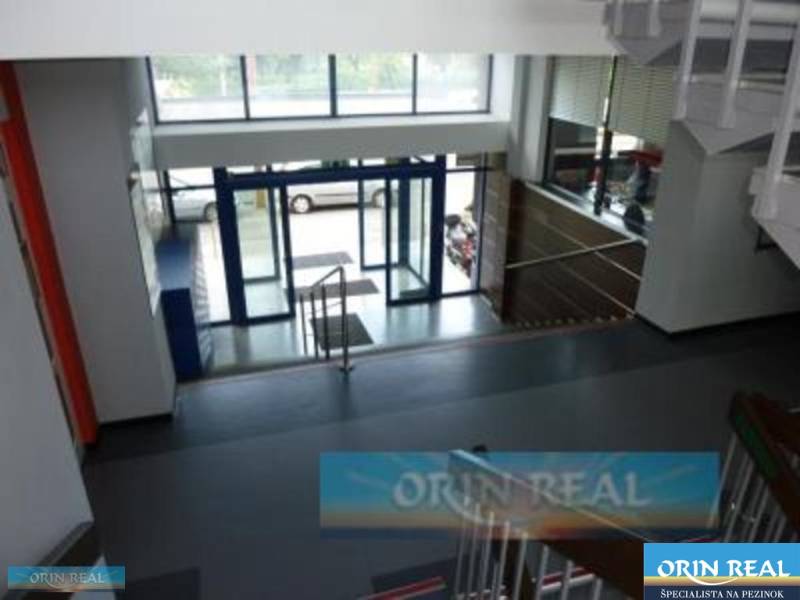 PRENÁJOM KANCELÁRSKÝCH PRIESTOROV NA RAČIANSKEJ ULICI - Vstupné schodisko so sklenými dverami, vedúcimi na ulici Račianska, za ktorými parkuje auto.