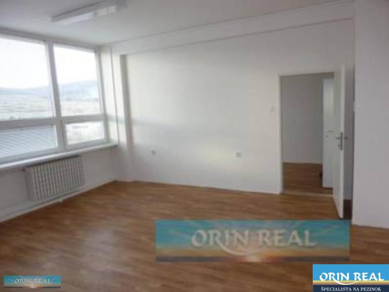 PRENÁJOM KANCELÁRSKÝCH PRIESTOROV NA RAČIANSKEJ ULICI - Svetlá miestnosť s veľkým oknom, drevenou podlahou a radiátorom v lokalite Račianska.