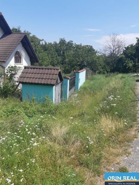 PREDAJ INVESTIČNÉHO POZEMKU V ŠENKVICIACH NA VÝSTAVBU RD - 2197 m2 - Trávnatý pozemok na Ružovej ulici v Šenkviciach s rodinným domom. Pozemky - bývanie.