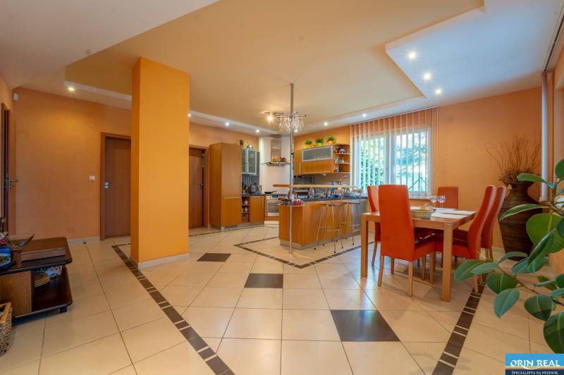 ,,,EXKLUZÍVNE,,,PREDAJ PRIESTRANNÉHO 5 IZB.RD V PEZINKU / LIMBACH - Interiér rodinného domu s kuchyňou, jedálenským stolom a oranžovými stenami.