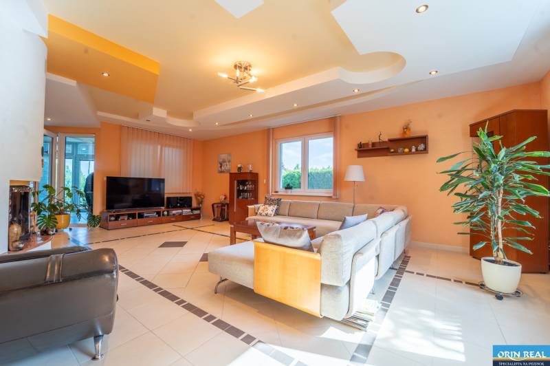 ,,,EXKLUZÍVNE,,,PREDAJ PRIESTRANNÉHO 5 IZB.RD V PEZINKU / LIMBACH - Obývacia izba v rodinnom dome s pohodlnou sedačkou a televízorom, svetlé steny.