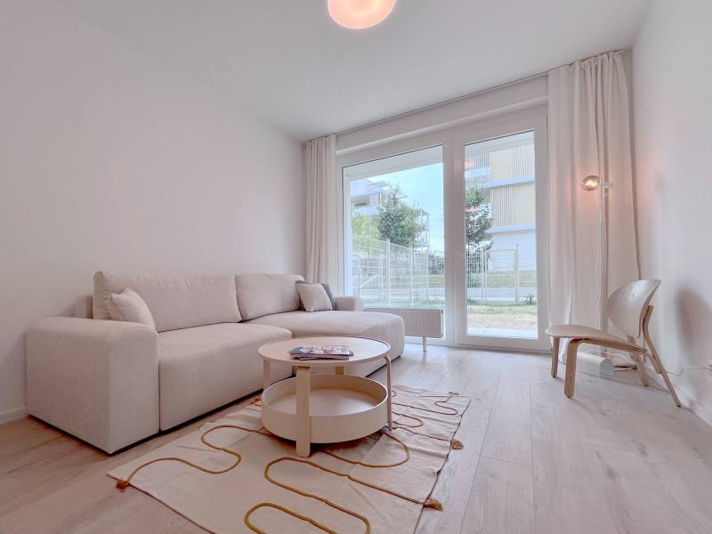 NUERA︱NOVÝ RUŽINOV - kompletne zariadený 2-izbový apartmán so záhradou - Obývacia izba v 2-izbovom byte s pohodlnou sedačkou a podlahou s dreveným dekorom.