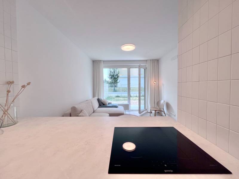 NUERA︱NOVÝ RUŽINOV - kompletne zariadený 2-izbový apartmán so záhradou - Kuchynský pult, sporák a svetlá obývačka s výhľadom v 2-izbovom byte.