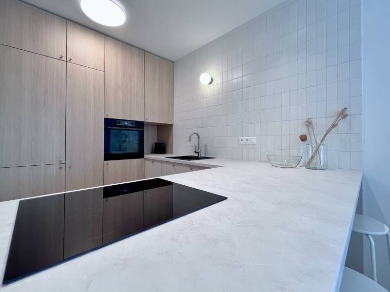 NUERA︱NOVÝ RUŽINOV - kompletne zariadený 2-izbový apartmán so záhradou - Kuchyňa v 2-izbovom byte s varnou doskou a skrytými úložnými priestormi.