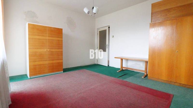 MARTIN-STRÁNE 5 izbový rodinný dom na predaj - Izba v rodinnom dome s kobercami, dvomi skriňami a stolom.