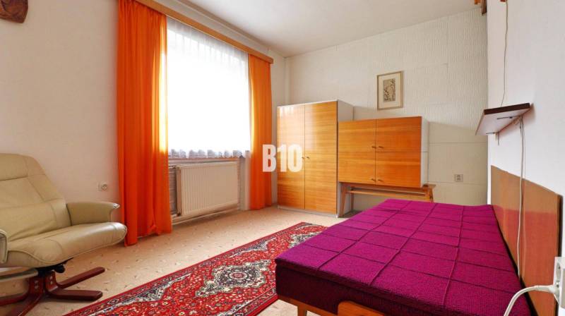 MARTIN-STRÁNE 5 izbový rodinný dom na predaj - Izba s kobercovou podlahou, krémovým kreslom, farebnou posteľou a skriňou v rodinnom dome.