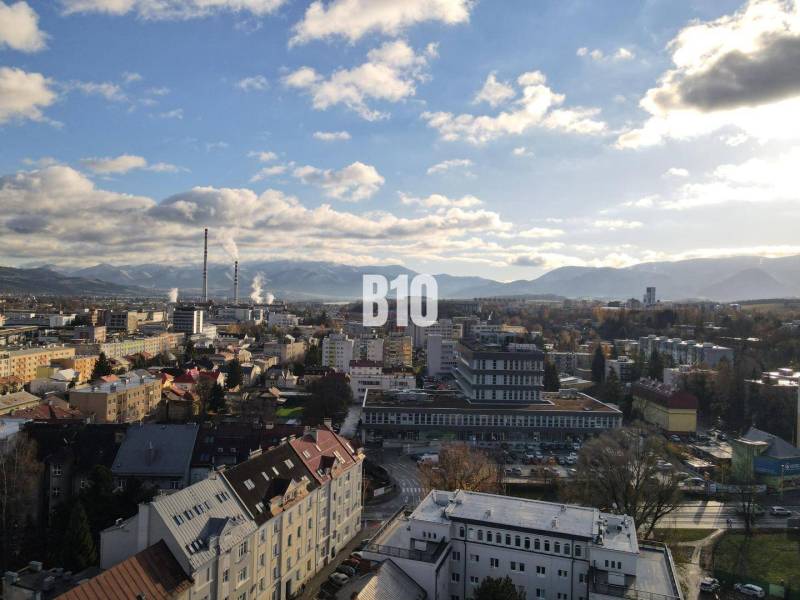 Sad na Studničkách - 2 izbový byt 60m2 - Mesto Žilina s panorámou, bytové domy a priemyselná zóna v popredí.