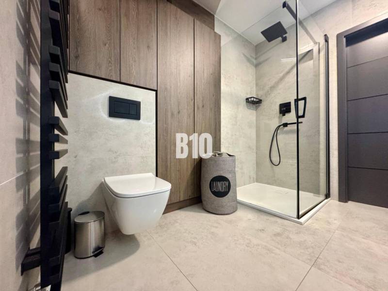 Moderný kompletne zrekonštruovaný Mezonet - centrum mesta - Kúpeľňa v 4-izbovom byte s WC, sprchou a podlahou s dreveným dekorom.