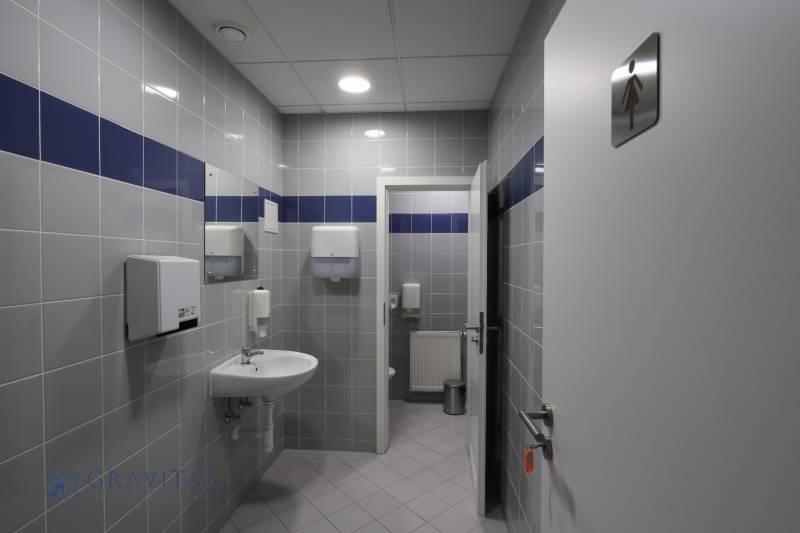 Kancelárie na prenájom: od 20m2 | Jarabinková ulica - Kancelárske toalety s bielymi a modrými obkladačkami, vybavené umývadlom a zásobníkmi na papier.