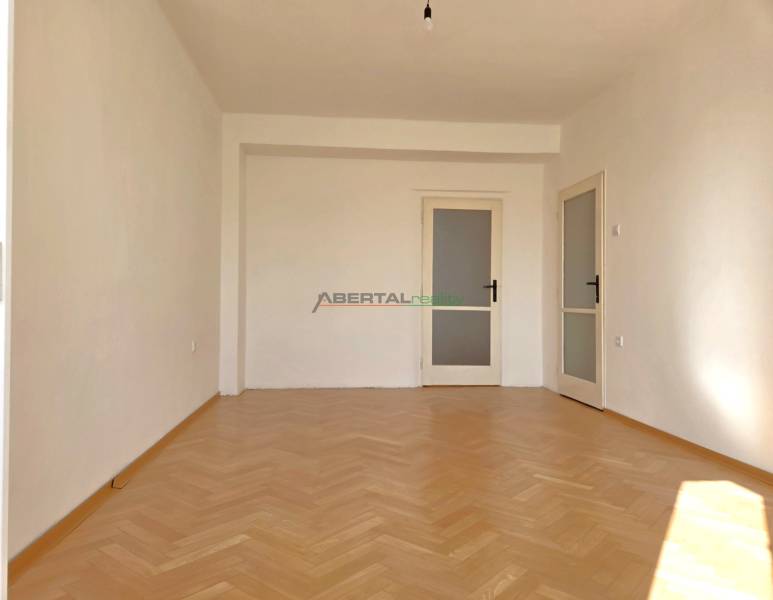 Predaj - 3 izbový byt,  69 m2, balkón,  ul.ČSA, KE - Staré Mesto - Izba v 3-izbovom byte má podlahu s dreveným dekorom a biele steny.