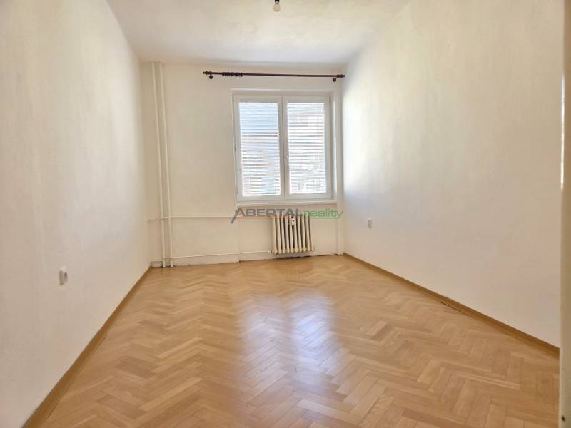 Predaj - 3 izbový byt,  69 m2, balkón,  ul.ČSA, KE - Staré Mesto - Prázdna miestnosť s podlahou s dreveným dekorom v 3-izbovom byte, jasné steny, radiátor.