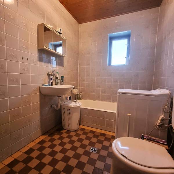 Rodinný dom na predaj - Znížená cena. - Kúpeľňa v rodinnom dome s vaňou, umývadlom a práčkou, dlažba v šachovnici.