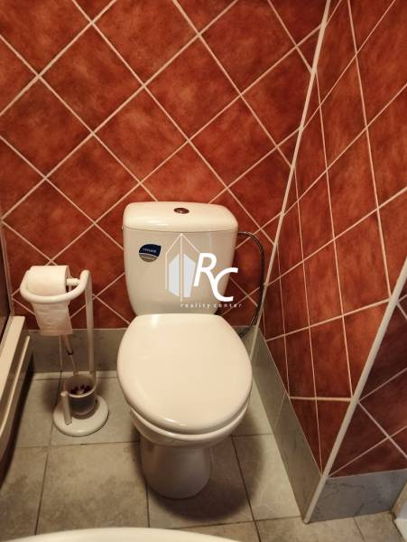 Prenájom 1-izbového bytu s energiami, Martin - Jahodníky - Kúpeľňa v 1-izbovom byte s WC, obklady hnedé, podlaha s kamenným dekorom.