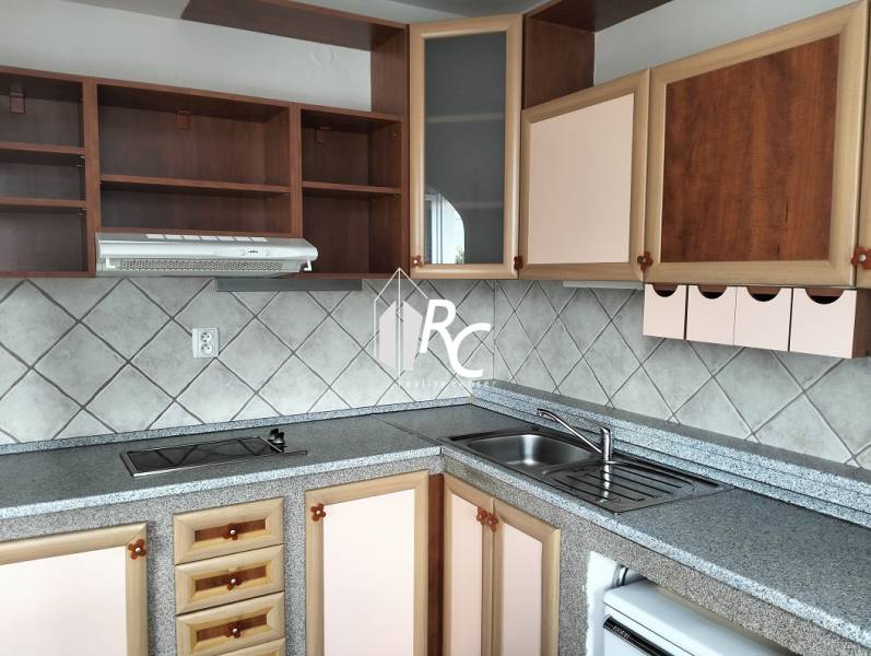 Prenájom 1-izbového bytu s energiami, Martin - Jahodníky - Kuchyňa v 1-izbovom byte s pracovnou doskou, skrinkami a kachličkami na stene.