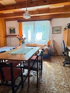 Rodinný dom (chalupa) na veľkom pozemku, Krúd - Bodovka - Obývacia izba v rodinnom dome s jedálenským stolom a kvetmi na ňom.