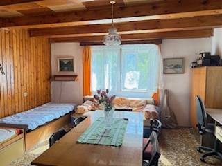 Rodinný dom (chalupa) na veľkom pozemku, Krúd - Bodovka - Izba v rodinnom dome s drevenými trámami, jedálenským stolom a dvomi lôžkami.
