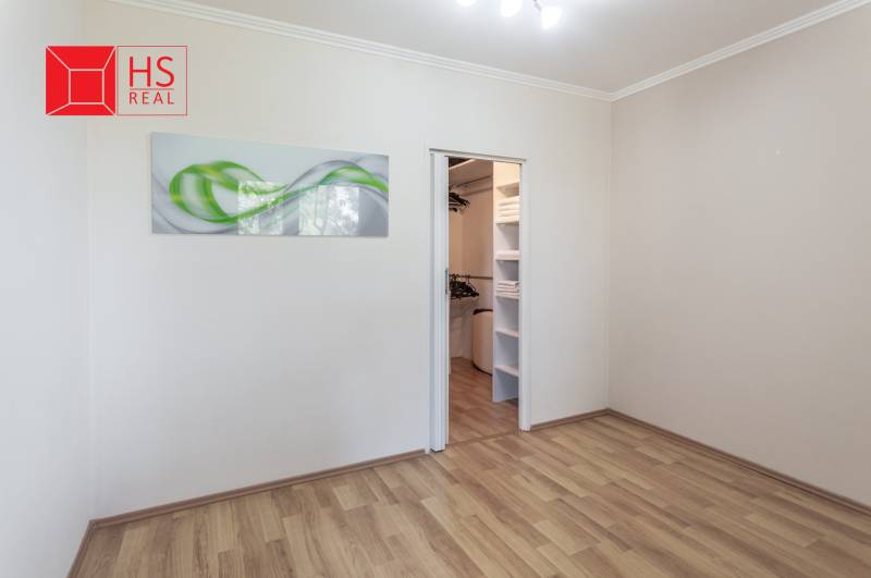 Predaj 3i bytu 84m2 - dva balkóny , Nábrežná v NZ - Izba s podlahou s dreveným dekorom a vstavaným šatníkom v 3-izbovom byte.