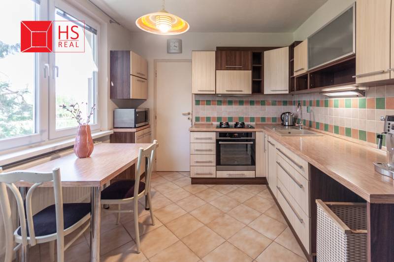 Predaj 3i bytu 84m2 - dva balkóny , Nábrežná v NZ - Kuchyňa s mozaikovým obkladom a stolom v 3-izbovom byte je vybavená spotrebičmi.