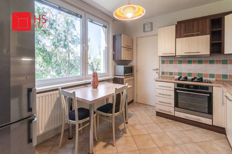 Predaj 3i bytu 84m2 - dva balkóny , Nábrežná v NZ - Kuchyňa v 3-izbovom byte s kachličkovanou stenou a podlahou s dreveným dekorom.