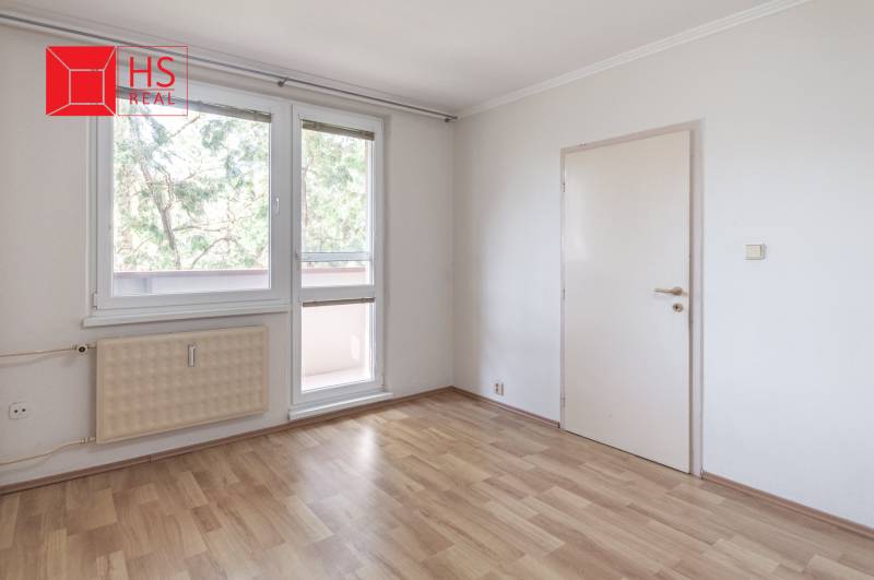 Predaj 3i bytu 84m2 - dva balkóny , Nábrežná v NZ - Izba v 3-izbovom byte s podlahou s dreveným dekorom a veľkými oknami.