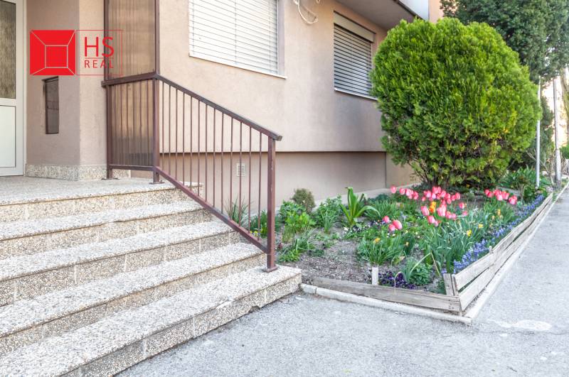 Predaj 3i bytu 84m2 - dva balkóny , Nábrežná v NZ - Vchod do 3-izbového bytu na Nábrežnej ulici v Nových Zámkoch s kvetinovou záhradkou.